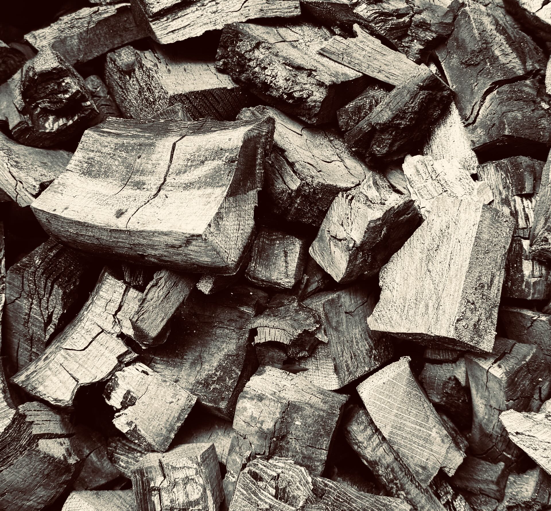 Neatly stacked oak logs along the riverbank awaiting the kiln